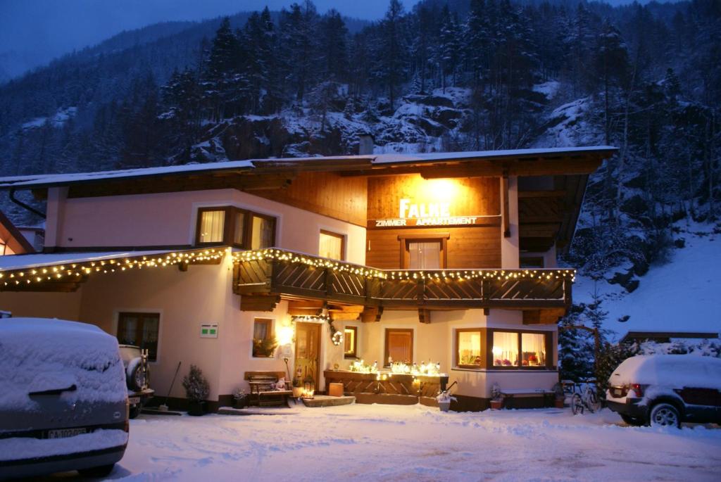 Una casa con luces de Navidad en la nieve en Haus Falke, en Sölden