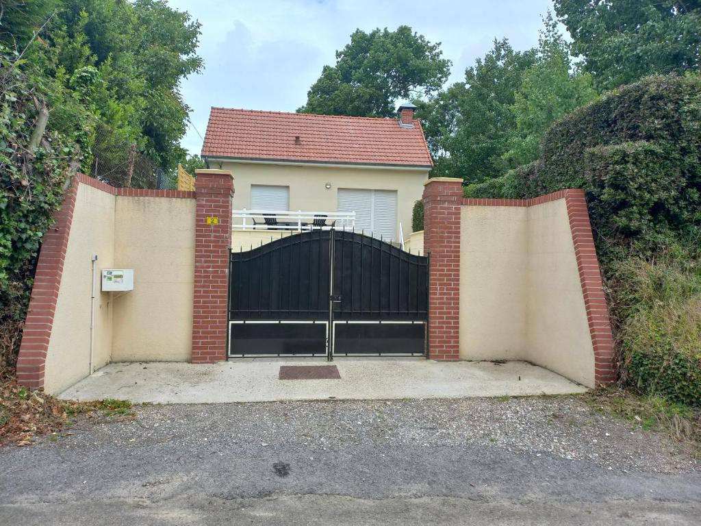 ein Tor zu einem Haus mit Auffahrt in der Unterkunft Gîte Au coeur de la Baie in Arrest