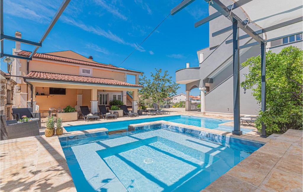 a swimming pool in front of a house at Beautiful Home In Brodarica With Wifi in Brodarica