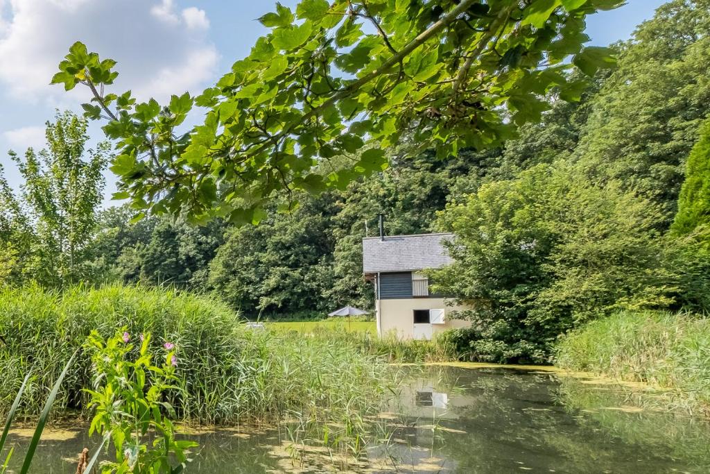 an old house in the middle of a river at Heavenly luxury rustic cottage in historic country estate - Belchamp Hall Mill in Belchamp Otten