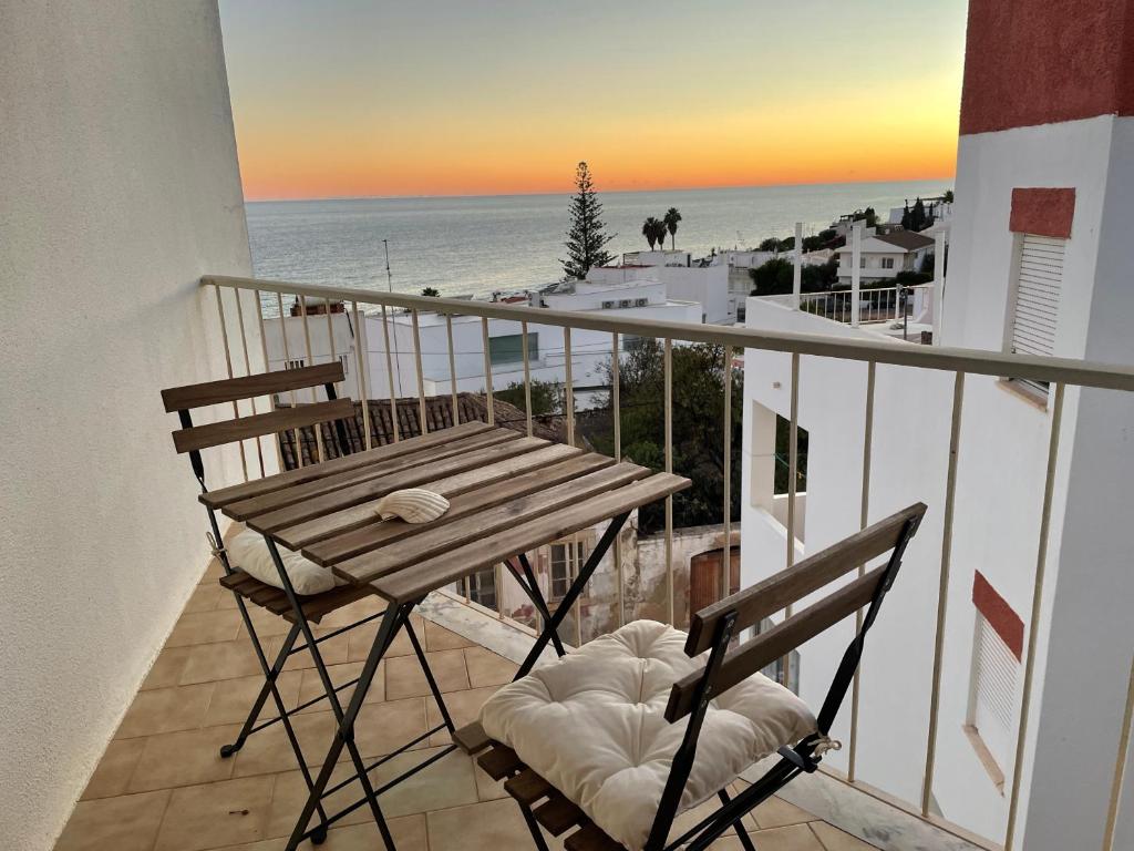 d'une table et de deux chaises sur un balcon donnant sur la plage. dans l'établissement M&M's Cosy apartment - Sea view, à Luz