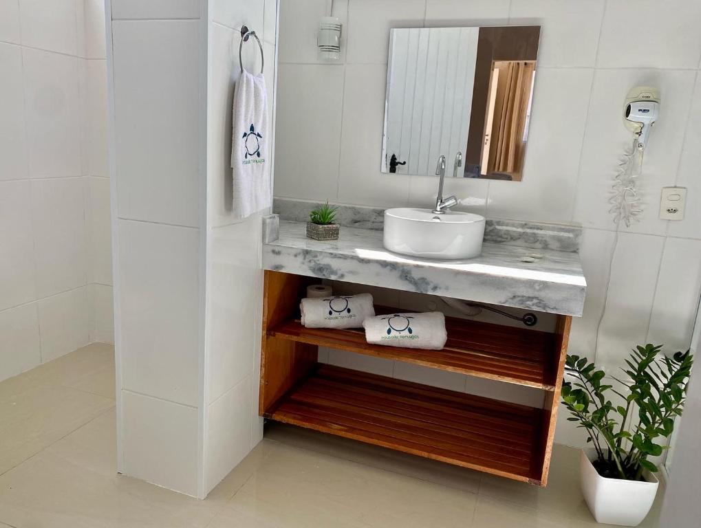 a bathroom with a sink and a mirror at Pousada Tortugas in Guarujá