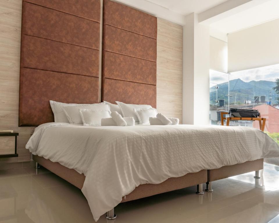 ein Schlafzimmer mit einem großen Bett und einem großen Fenster in der Unterkunft Primavera Plus in Villavicencio