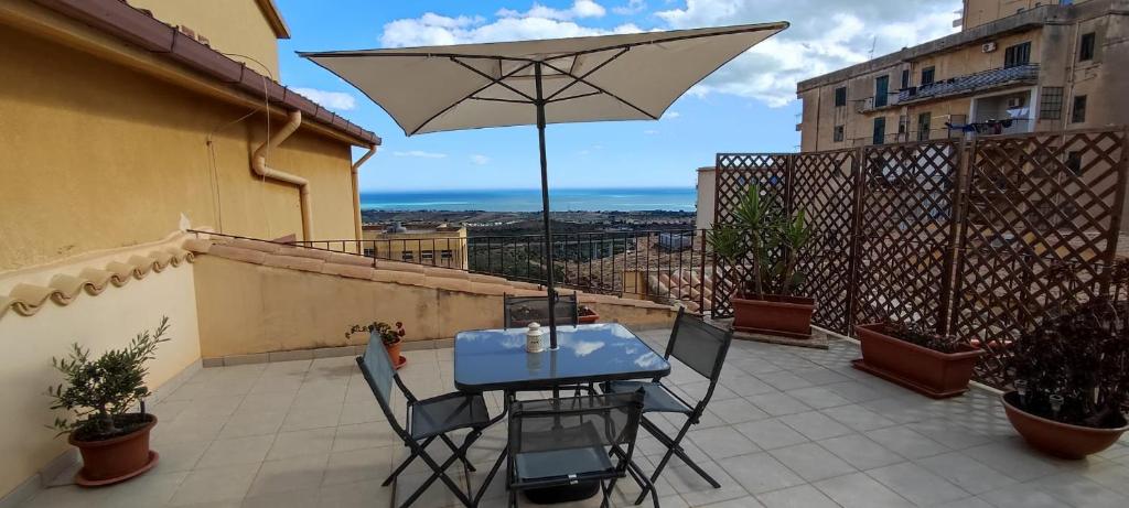 un tavolo e sedie con ombrellone su un balcone di B&B Anita a Agrigento