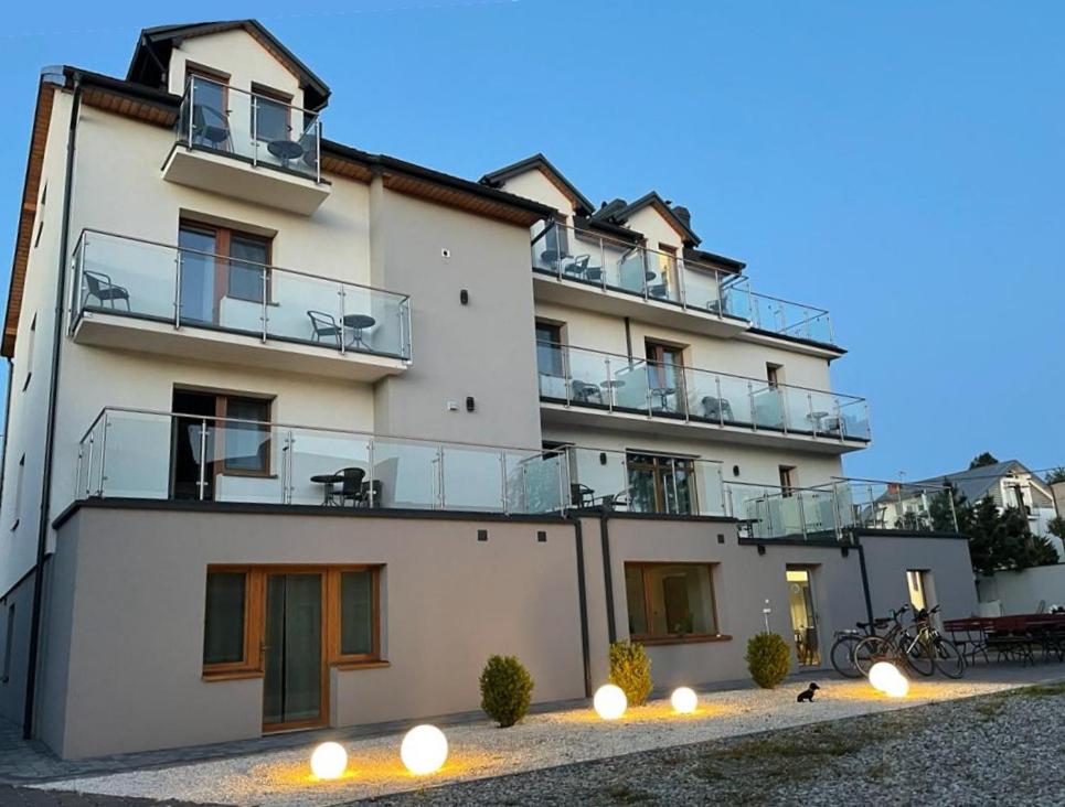 a large white building with lights in front of it at La Mer Pokoje i Apartamenty in Władysławowo