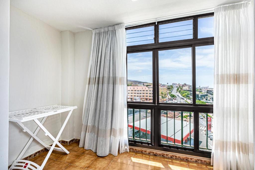 ein Zimmer mit einem großen Fenster und einem weißen Schreibtisch in der Unterkunft Vivienda Vacacional Playa La Arena in Puerto de Santiago