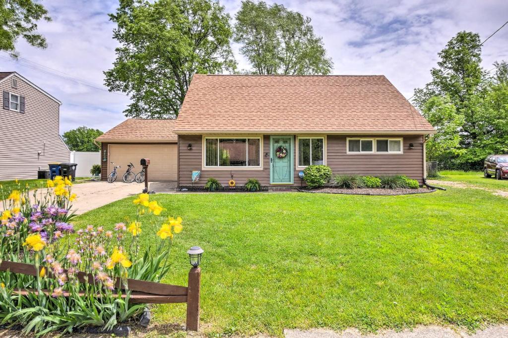a house with a green yard with flowers at Ashtabula Home Near Walnut Beach and Eateries! in Ashtabula