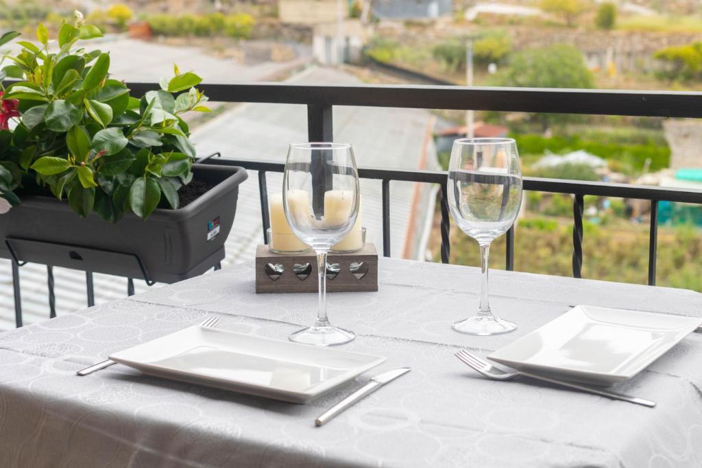 una mesa con 2 vasos y platos en el balcón en H11 ATTICO AL MARE - Santo Stefano al Mare - Grande Terrazzo, en Santo Stefano al Mare