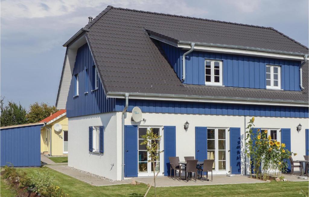 a blue and white house with a black roof at Ferienhaus 33 Altefähr in Altefähr