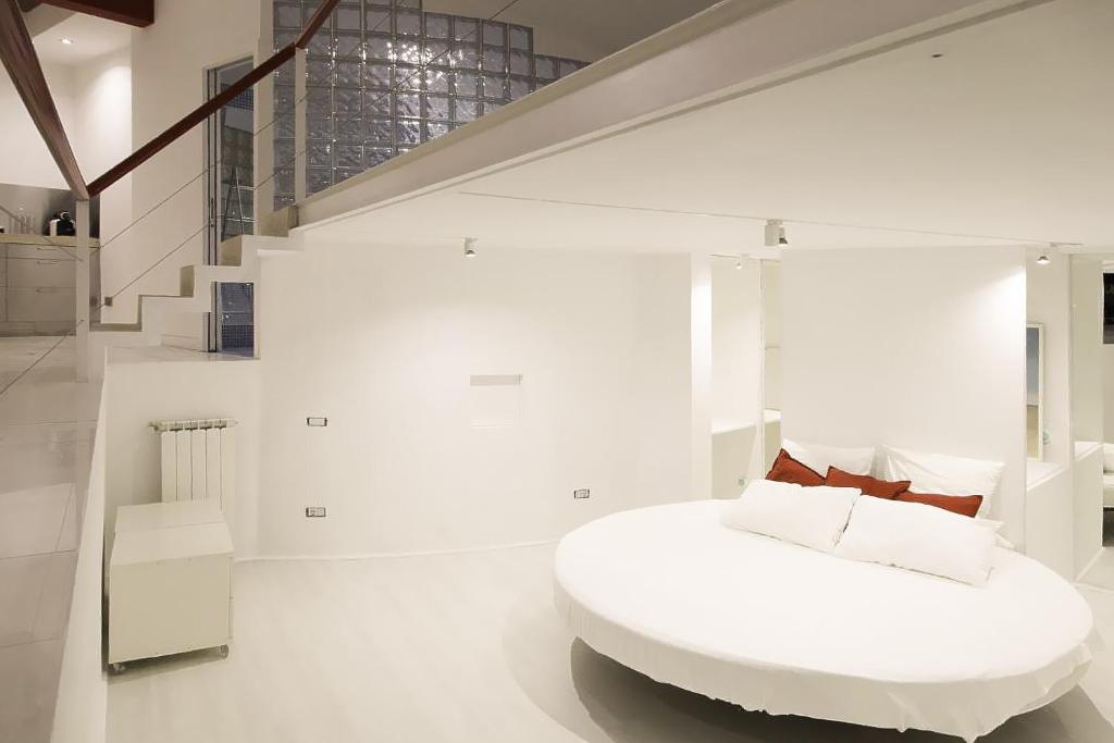 um quarto branco com uma cama branca e uma escada em Vatican Modern Designer Loft em Roma