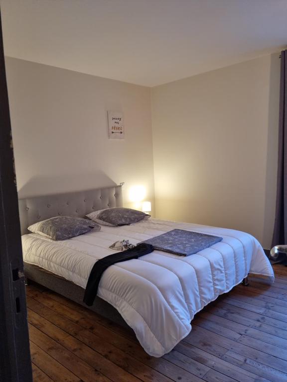 sypialnia z dużym łóżkiem z białą pościelą w obiekcie La maison de Lily au cœur de la cité Médiévale w mieście Sarlat-la-Canéda
