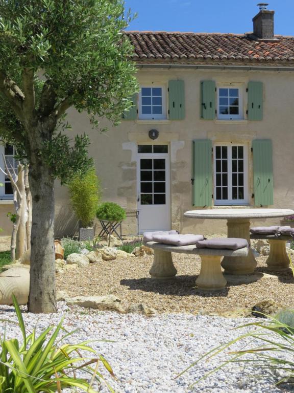 a house with a picnic table in front of it at Les vieilles pierres in Aumagne