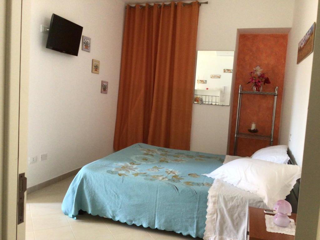 um pequeno quarto com uma cama e uma cómoda em Lu Caleddhu em Specchia