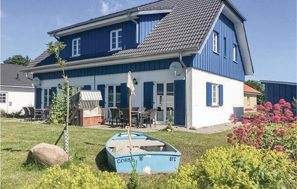 ein blau-weißes Haus mit einem Boot im Hof in der Unterkunft Ferienhaus 34 Altefhr in Altefähr