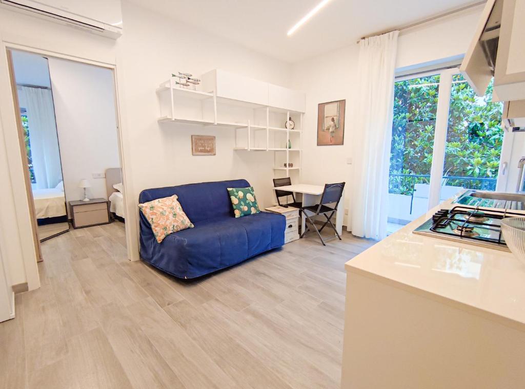 een woonkamer met een blauwe bank en een tafel bij Casa di Bubs - By Ligooria in Pietra Ligure