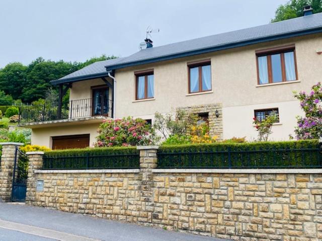 une maison avec un mur de pierre et une clôture dans l'établissement Gite la Mie de Pain, à Bogny Sur Meuse