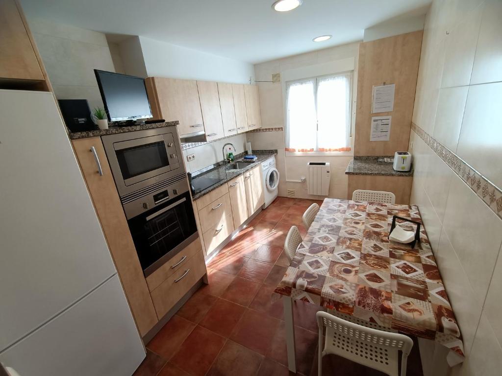 a kitchen with a table and a kitchen with a table and a kitchen at PM70 Apartment in San Sebastián