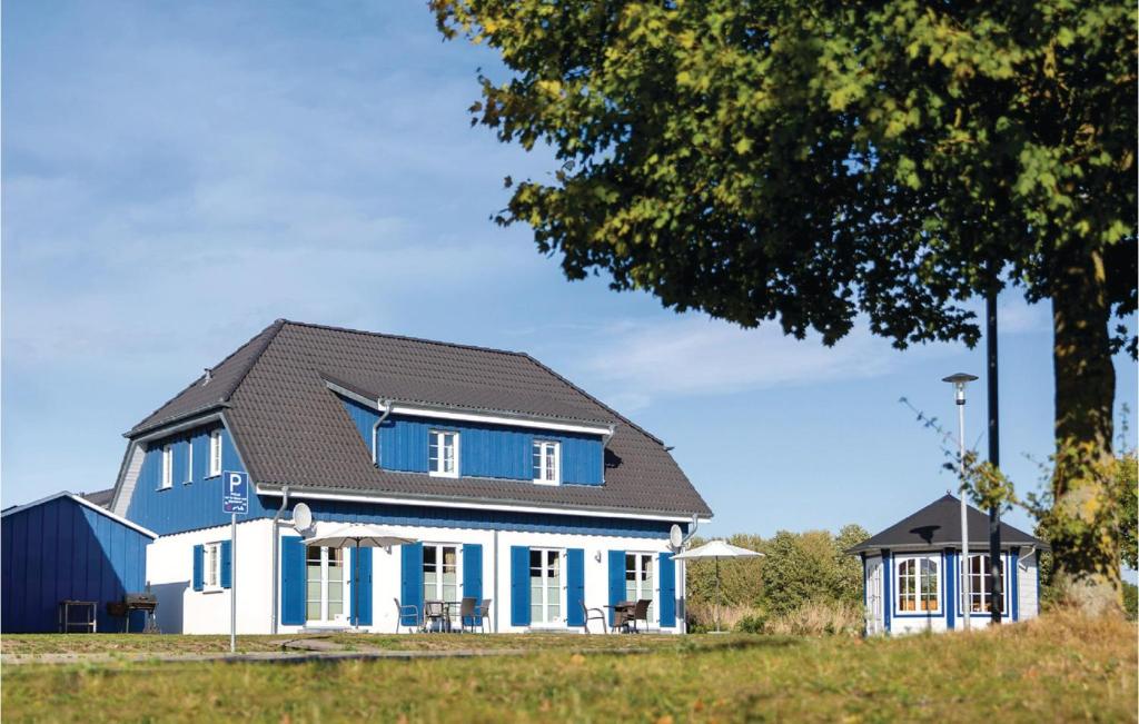 niebiesko-biały dom z czarnym dachem w obiekcie Ferienhaus 6 Altefhr w mieście Altefähr