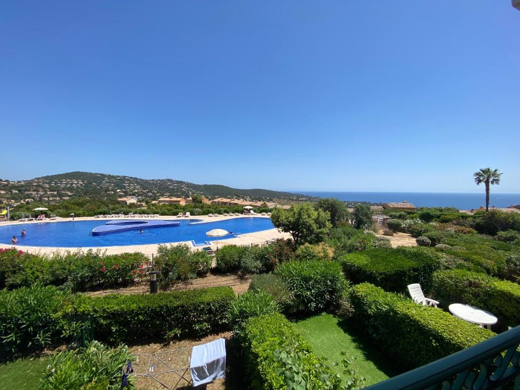 uma vista para uma piscina e para o oceano em Appart. vue mer avec piscine - Golfe de St Tropez em Les Issambres