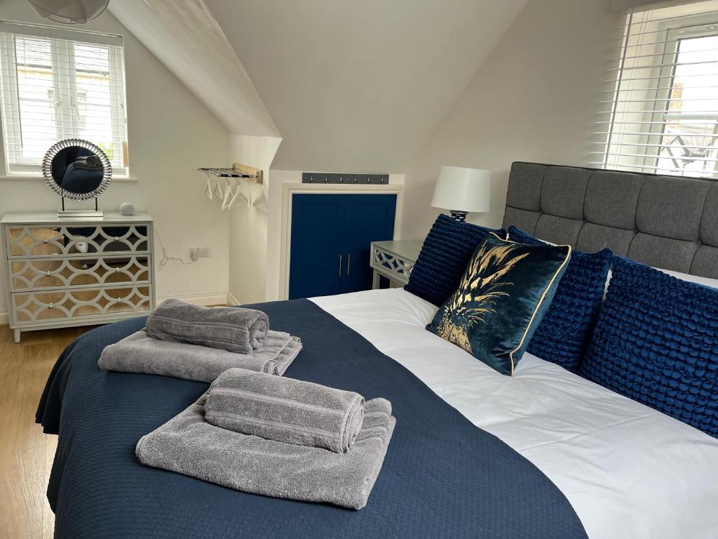 a bedroom with a large bed with towels on it at Exmouth Luxury Coastal Boutique Town House in Exmouth