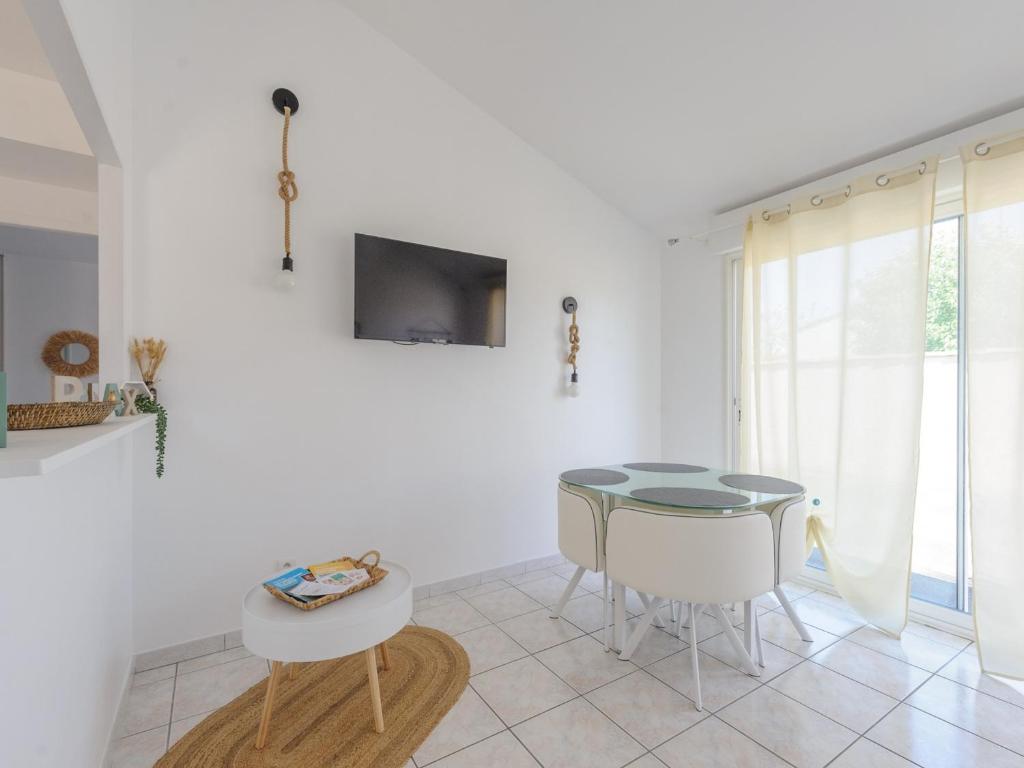 a white living room with a table and a chair at Appartement La Jarne, 2 pièces, 4 personnes - FR-1-535-35 in La Jarne