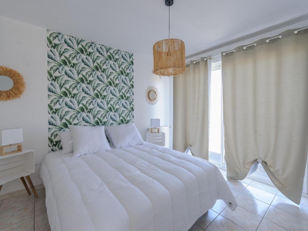 a bedroom with a large white bed with a large window at Appartement La Jarne, 2 pièces, 4 personnes - FR-1-535-35 in La Jarne