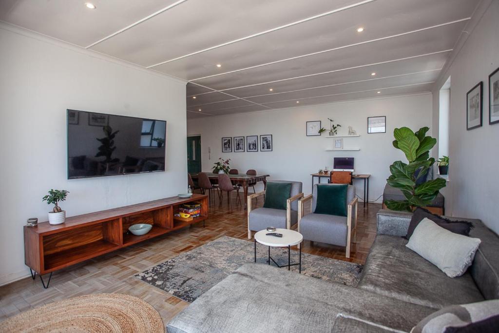 a living room with a couch and a flat screen tv at Cremorne on Beach Road in Summerstrand