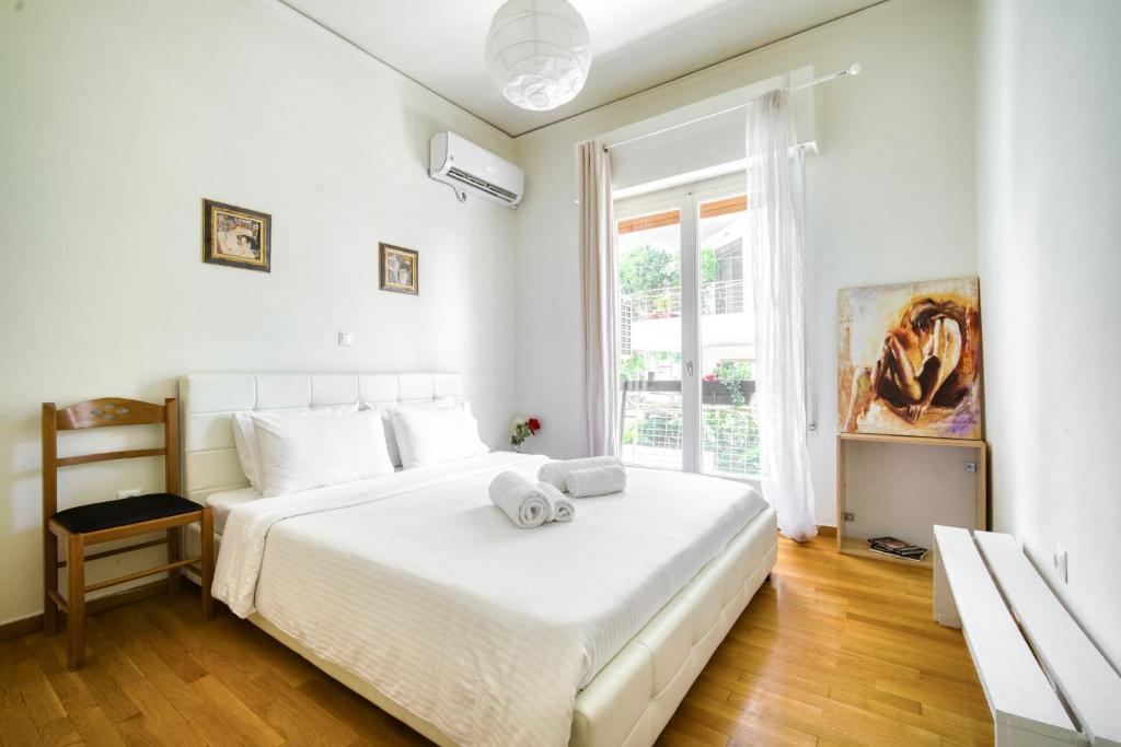 biała sypialnia z dużym łóżkiem i oknem w obiekcie Elegant flat at Acropolis w Atenach