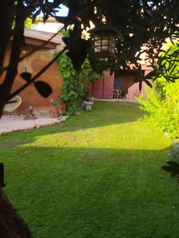 a yard with green grass and a building at Ca l'Àvia Remei in Castelló d'Empúries