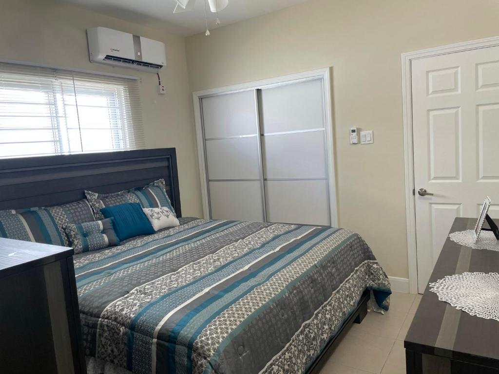 a bedroom with a bed with a blue comforter at Aquamarine Resort-style Vacations in Lucea
