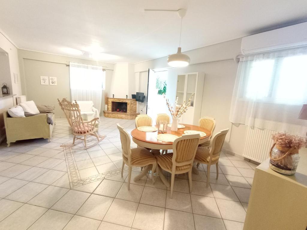 a dining room and living room with a table and chairs at Galini apartment near sea, port and airport in Artemida