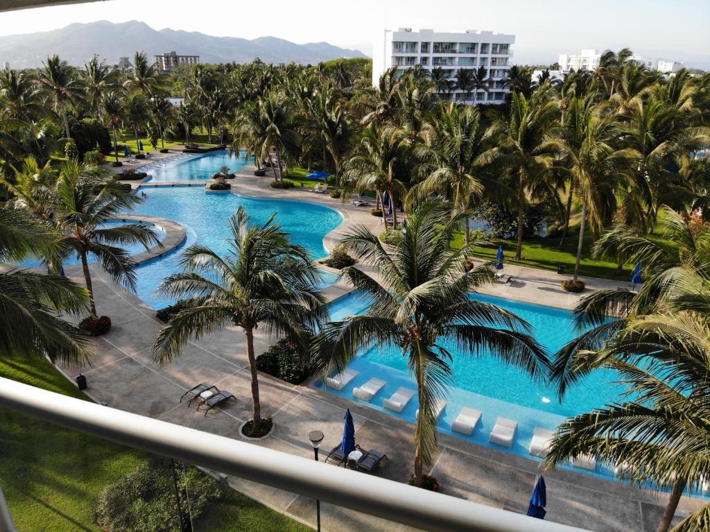 een balkon met uitzicht op het zwembad van een resort bij Mayan Lake Horus in Acapulco