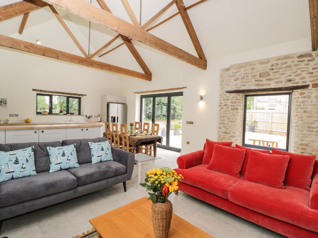 a living room with a red couch and a table at The Old Stables in Gillingham