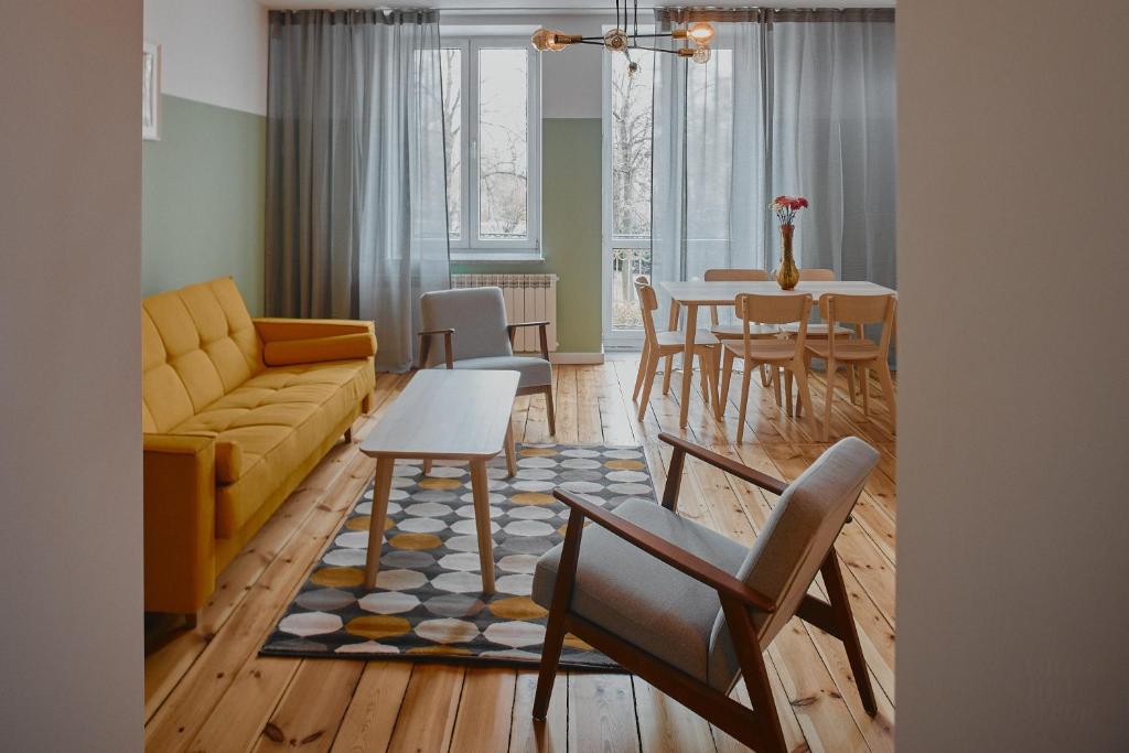 a living room with a couch and a table and chairs at Apartament D16 in Pińczów