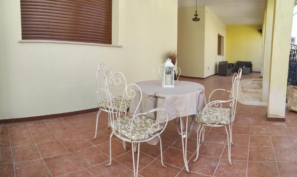 stół z białymi krzesłami i stół z wazonem w obiekcie Casa Salento w mieście Novoli