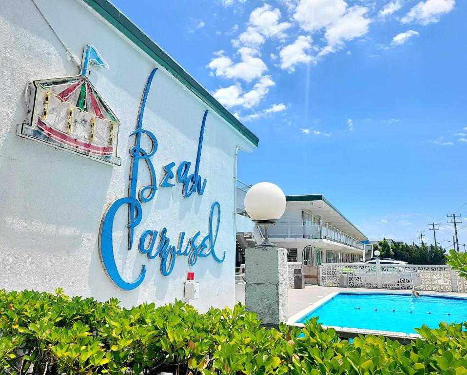 una señal en el lateral de un edificio con piscina en Beach Carousel Virginia Beach en Virginia Beach