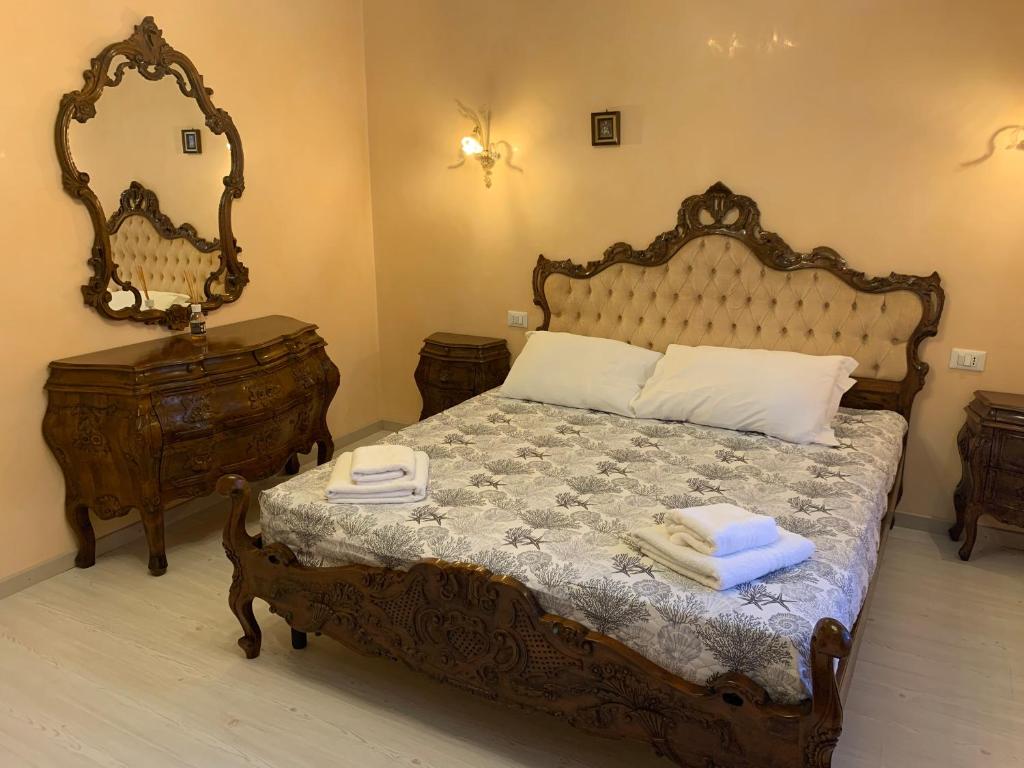 Schlafzimmer mit einem großen Holzbett und einem Spiegel in der Unterkunft Casa Flavio in Venedig