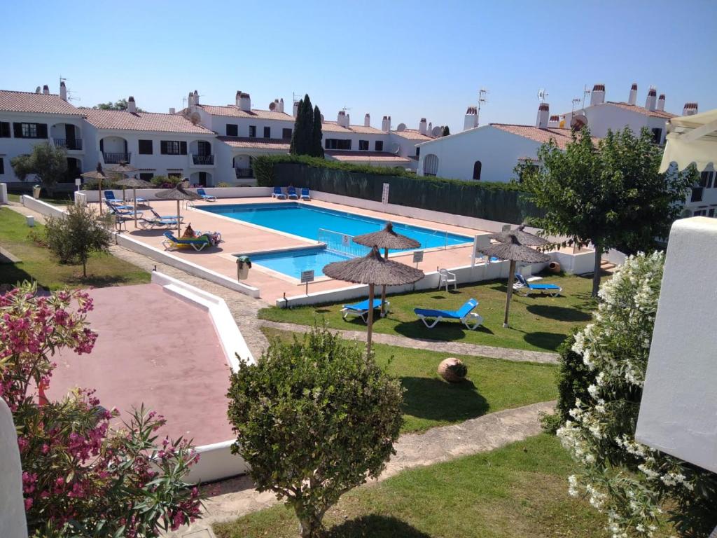 a view of a swimming pool with umbrellas at Apartamento Siesta Mar 1 Apartamento 26 Cala en Porter in Cala'n Porter