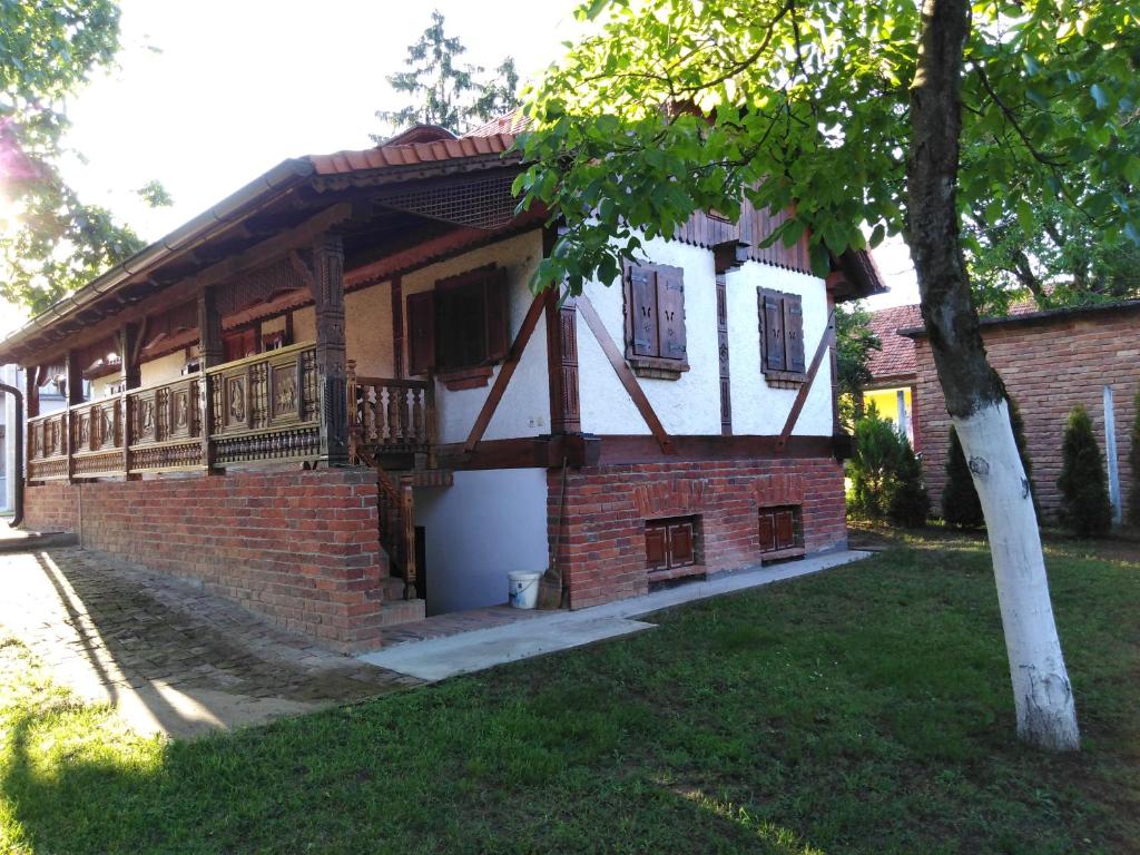 ein Backsteinhaus mit einem Balkon und einem Baum in der Unterkunft Umjetnička etno kuća Luka in Podravske Sesvete