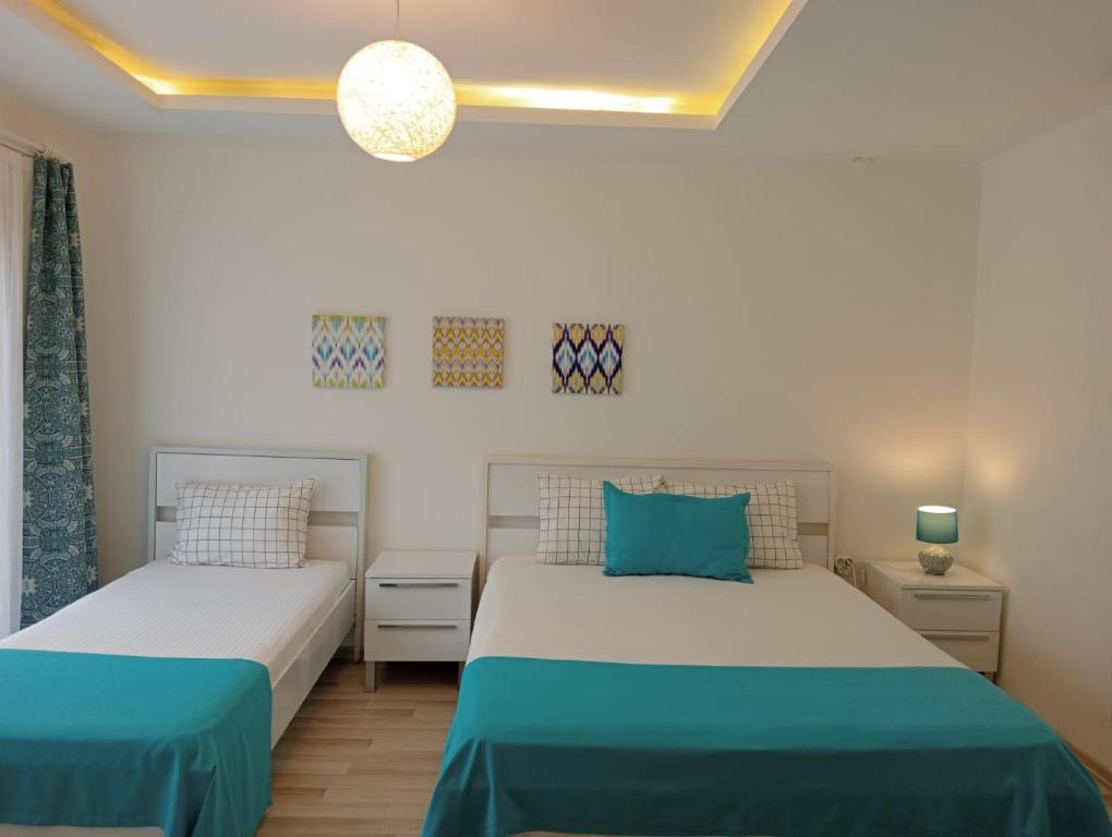two beds in a bedroom with blue and white at Daffne Otel in Canakkale