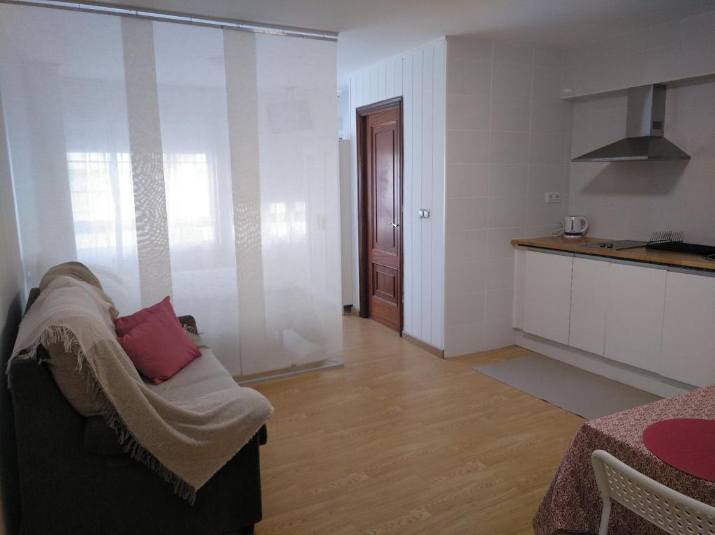 salon z kanapą i kuchnią w obiekcie Céntrico Estudio w mieście Sada