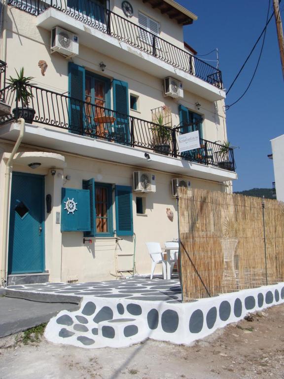 a building with blue shuttered windows and a fence at PANSION KONSTANTINOS in Skiathos
