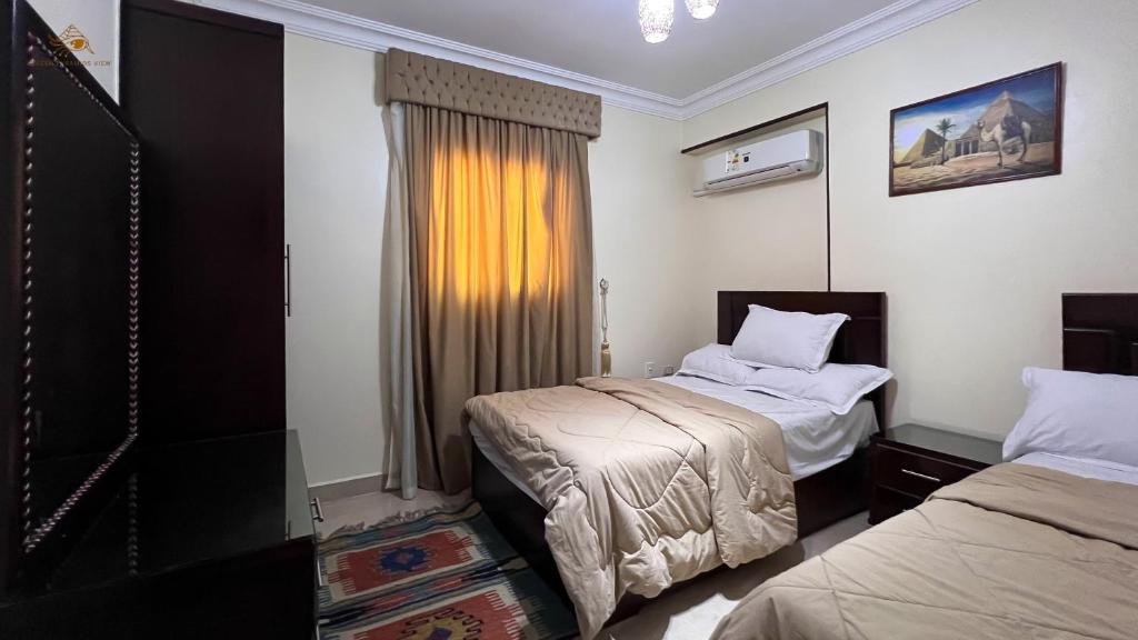 מיטה או מיטות בחדר ב-Queen Pyramids View Apartment