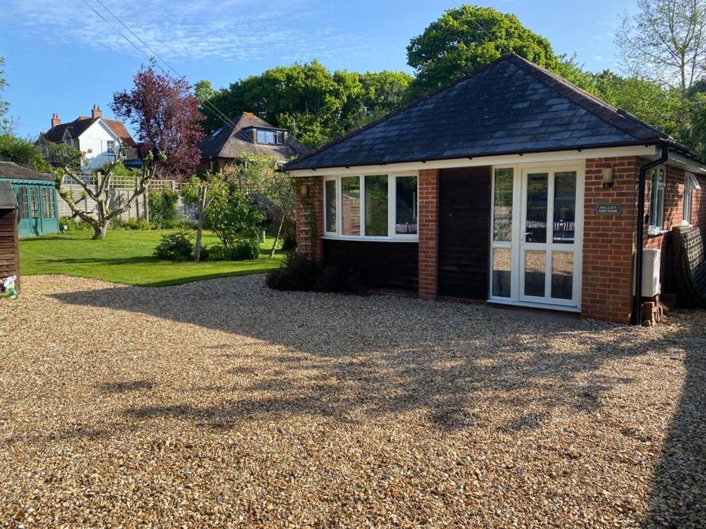 a detached house with a gravel driveway at Quiet coastal cottage, perfect for walkers due to its natural location in Lymington