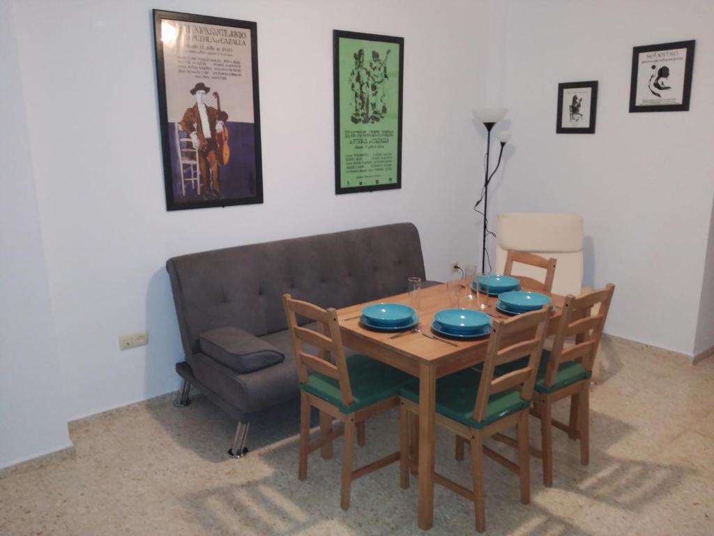 mesa de comedor con sillas y sofá en Apto para Vacaciones con WIFI, en Chipiona