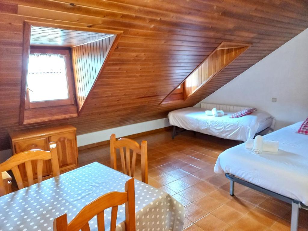 タウイにあるEstudi Casa Xullaのベッド2台、テーブル、椅子が備わる客室です。