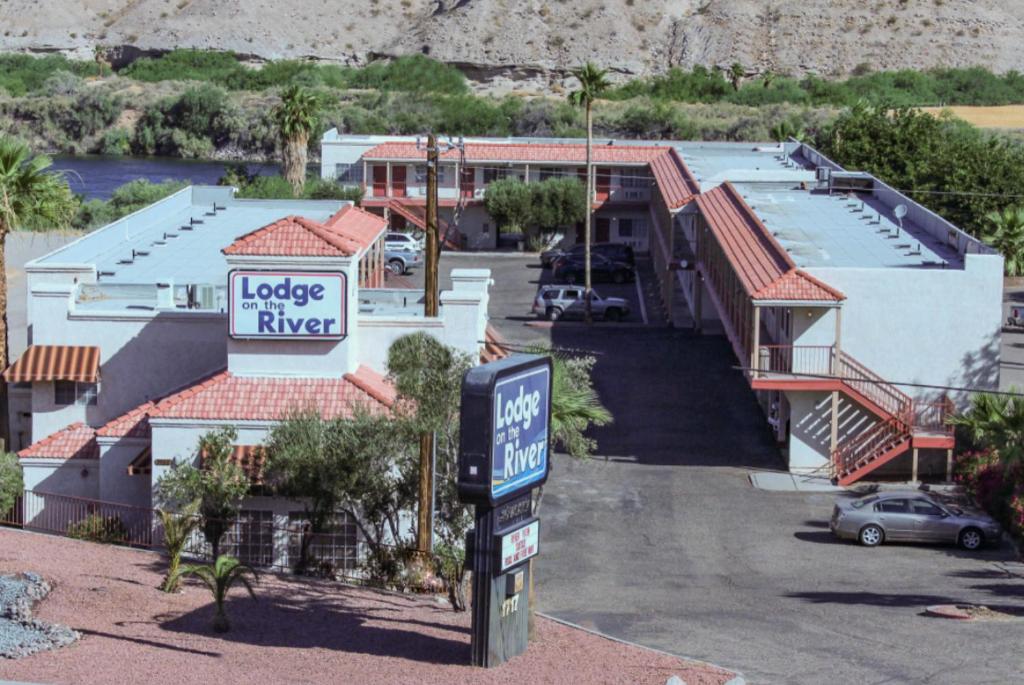 Un cartel delante de una casa con garaje. en lodge on the river, en Bullhead City