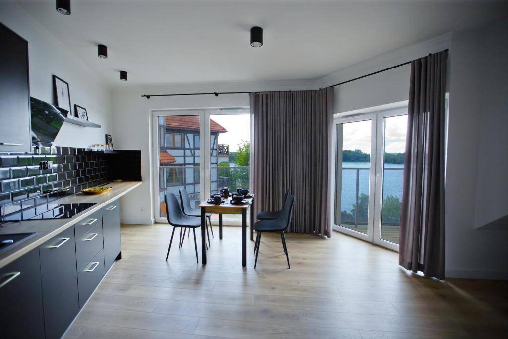 a kitchen with a table and chairs and a dining room at Ełk apartamenty in Ełk