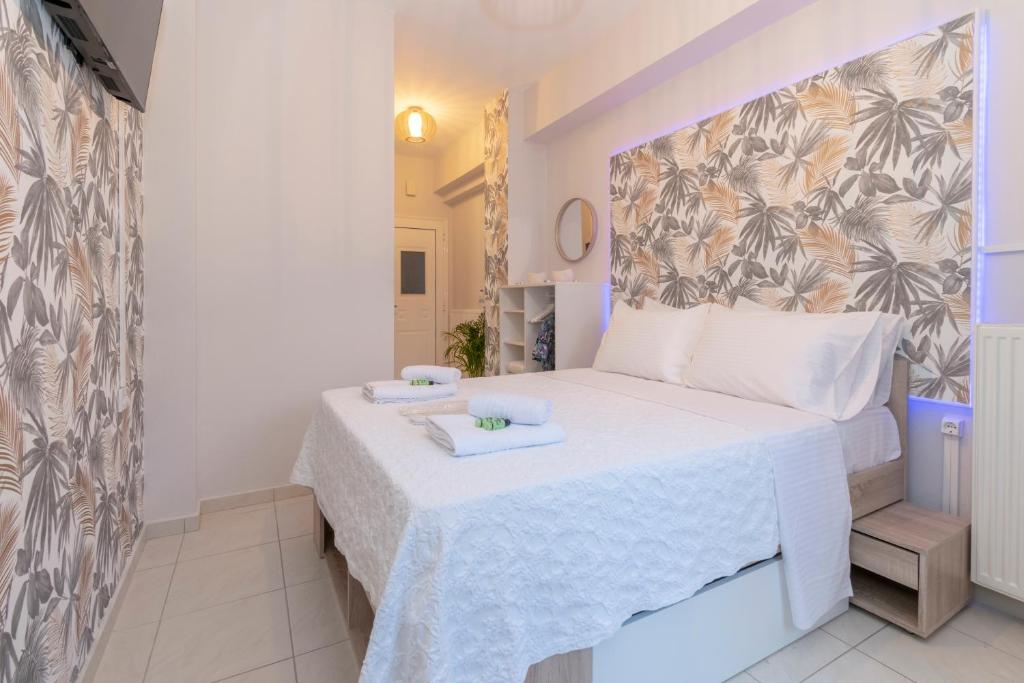 a small bedroom with a bed with white sheets at Koper House - Cozy & Tropical Oasis steps from the center in Neos Marmaras