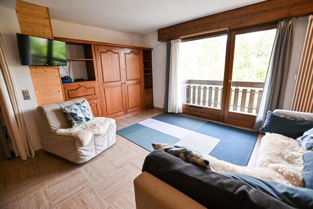 ein Wohnzimmer mit einem Sofa, Stühlen und einem TV in der Unterkunft Charming 50m With Balcony In Megève ! in Megève